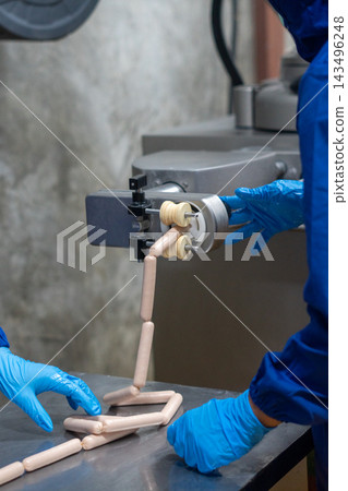 Worker Operating Sausage Linking Machine in Meat Processing Factory Worker Operating Sausage Linking Machine in Meat Processing Factory 143496248