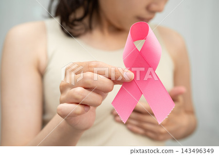 Asian woman with pink ribbon for October world breast cancer day. Asian woman with pink ribbon for October world breast cancer day. 143496349