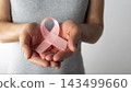 Person Holding Pink Ribbon for Breast Cancer Awareness 143499660