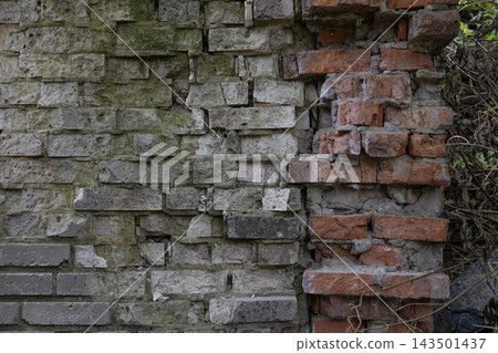 Ruined old brick wall texture with moss, grey blocks and damaged red clay masonry. Vintage abandoned industrial background for architectural design, grunge urban patterns and historical decay. Ruined old brick wall texture with moss, grey blocks and damaged red clay masonry. Vintage abandoned industrial background for architectural design, grunge urban patterns and historical decay. 143501437