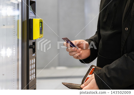 A person uses a bank card at a vending machine terminal for contactless payment, representing digital financial transactions and modern convenience in a quick service retail store A person uses a bank card at a vending machine terminal for contactless payment, representing digital financial transactions and modern convenience in a quick service retail store 143502009