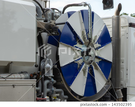 A large blue and white industrial hose reel on a utility truck for sewer cleaning operations, showing heavy duty plumbing maintenance equipment for municipal urban infrastructure repair 143502395