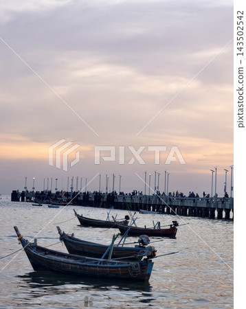 a traditional wooden fishing boat floating on calm coastal waters under an overcast or twilight sky, accompanied by a small orange mooring buoy a traditional wooden fishing boat floating on calm coastal waters under an overcast or twilight sky, accompanied by a small orange mooring buoy 143502542