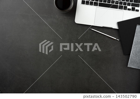 Top view of dark stone desk background with laptop, notebook and office supplies with large copy space Top view of dark stone desk background with laptop, notebook and office supplies with large copy space 143502790