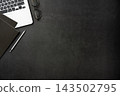 Top view of dark stone desk background with laptop, notebook and office supplies with large copy space 143502795