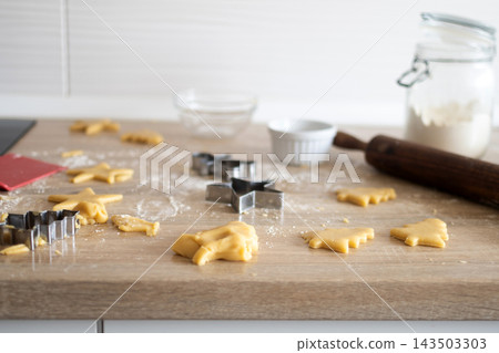Homemade Christmas cookie dough and cutters on kitchen counter 143503303