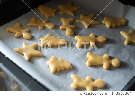 Raw Christmas cookies arranged on baking tray 143503304