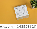 The August 2027 desk calendar with potted plant on yellow background 143503615