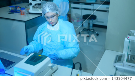 Female Scientist in Protective Gear Operating Laboratory Equipment in Modern Research Facility Female Scientist in Protective Gear Operating Laboratory Equipment in Modern Research Facility 143504477