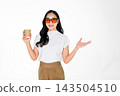 Asian Girl with Sunglasses Holding Coffee Cup Presenting on White Background 143504510
