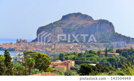 Cefalu, Italy. 22 August 2026. A panoramic view of the old town, situated right by the sea and featuring beautiful architecture. The La Rocca rock towers over the town. Cefalu, Italy. 22 August 2026. A panoramic view of the old town, situated right by the sea and featuring beautiful architecture. The La Rocca rock towers over the town. 143504949