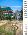 Masaryk's cottage stands on Serlich in the Orlicke Mountains. The path leads up to the cottage surrounded by grass and trees. Clear blue skies can be seen above. 143505186