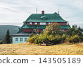 Masaryk's cottage on Serlich stands in the Orlicke Mountains. It is a well-known spot, surrounded by trees and grassy fields. Visitors often enjoy activities nearby in nature. 143505189