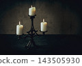 Vintage cast iron candelabrum with three burning candles on the table in the dark, copy space. 143505930