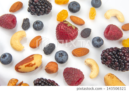 Mixed berries and nuts arranged on a white background for healthy snacking options Mixed berries and nuts arranged on a white background for healthy snacking options 143506321