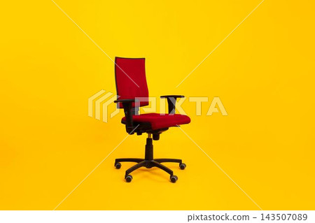 Stylish Office Ergonomic Red Chair Positioned Against Bright Yellow Background, Ideal For Workspace Seating Solutions. Emphasizes Comfort And Modern Design In An Office Environment. Business Concept. 143507089