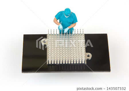 Miniature people working on a computer chip at a lab setting Miniature people working on a computer chip at a lab setting 143507332