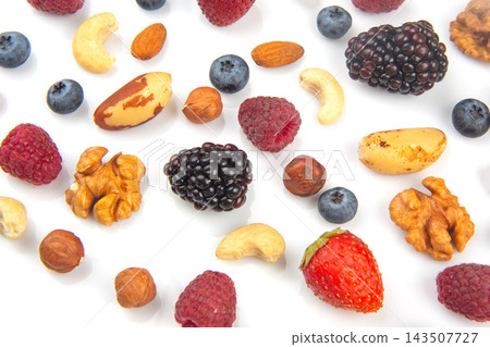 Various nuts and berries arranged on a white surface Various nuts and berries arranged on a white surface 143507727