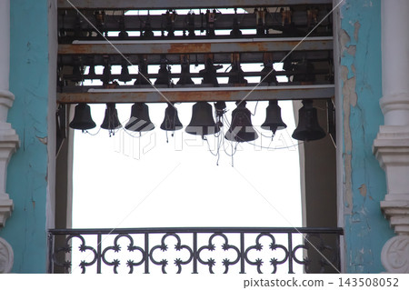 Bells hanging from a structure near an open space with a clear sky in the background Bells hanging from a structure near an open space with a clear sky in the background 143508052