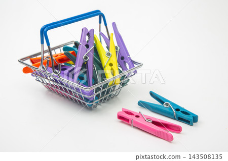 Colorful clothespins in a metal basket on a plain background 143508135