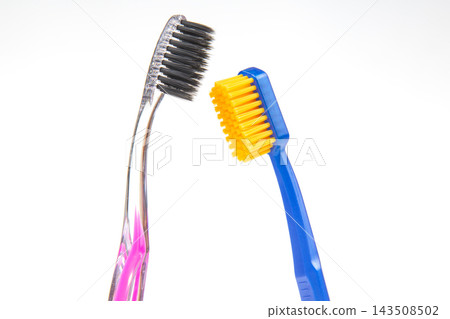 Two toothbrushes with different colors and bristle designs placed next to each other Two toothbrushes with different colors and bristle designs placed next to each other 143508502