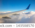 View of an airplane wing above white clouds during daytime 143508570