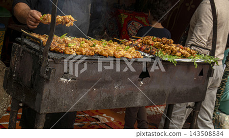 Traditional chicken skewers grilling over charcoal barbecue at street food market 143508884
