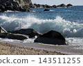Turquoise Sea Wave Breaking Behind Dark Coastal Rocks 143511255