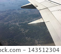 從空中俯瞰飛機機翼、山脈和城市景觀。 143512304