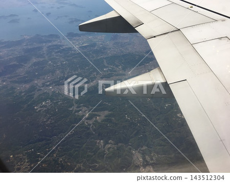 從空中俯瞰飛機機翼、山脈和城市景觀。 從空中俯瞰飛機機翼、山脈和城市景觀。 143512304