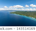 Lush green coastline meeting the deep blue sea along the shore of Anda, Bohol, Philippines 143514169