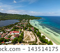 Aerial view of the village buildings along the shore with turquoise water and green vegetation in Anda, Bohol, Philippines 143514175