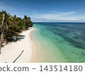 White sand beach meeting turquoise sea, palm trees lining the shore with wooden boats in Anda, Bohol, Philippines 143514180