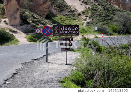 土耳其卡帕多西亞的烏奇薩城堡，坐落在岩石露頭上，旁邊立著旅遊指示牌。 143515305