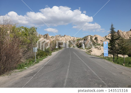 一條公路蜿蜒穿過土耳其卡帕多西亞的岩層。 一條公路蜿蜒穿過土耳其卡帕多西亞的岩層。 143515316