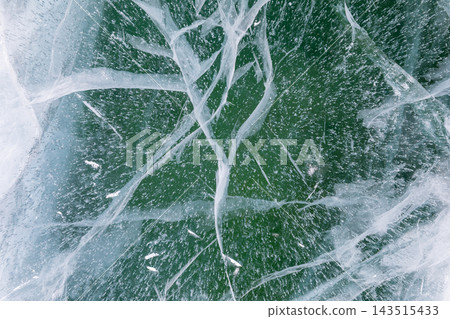 Deep turquoise cracked ice texture of frozen Lake Baikal in winter 143515433