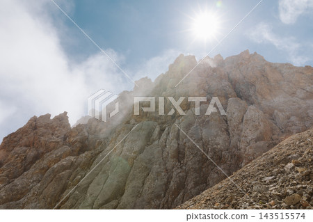 Rocky peaks of Mount Shalbuzdag under bright sun and clouds 143515574