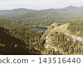 Scenic aerial view of mountain lake surrounded by dense taiga forest 143516440