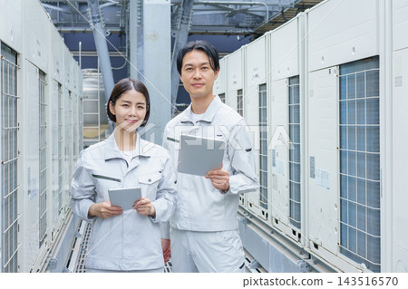 一幅描繪兩名日本年輕人（一男一女）手持平板電腦進行建築維護工作的肖像。 143516570
