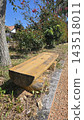 Old wooden boat covered with tarp on green grass yard 143518011
