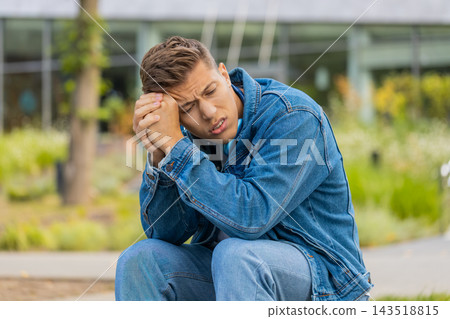 Young man feeling stress fatigue and worry in city street showing anxious serious portrait outdoors Young man feeling stress fatigue and worry in city street showing anxious serious portrait outdoors 143518815