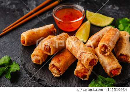 Fried spring rolls served with sauce and lime 143519084