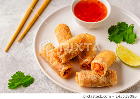 Fried spring rolls served with lime and sauce 143519086