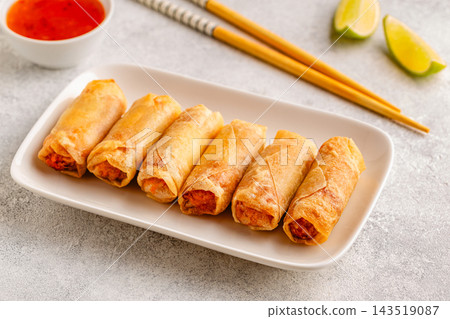 Fried spring rolls served with lime and sauce 143519087