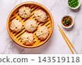 Steaming basket filled with dumplings on a marble table 143519118