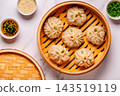 Steaming basket filled with dumplings on a marble table 143519119