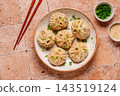 Dumplings served with green onions on a plate 143519124