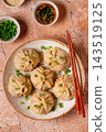 Dumplings served with green onions on a plate 143519125