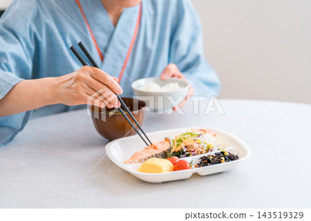 一位老年女住院病人正在醫院享用營養均衡的餐點。 143519329