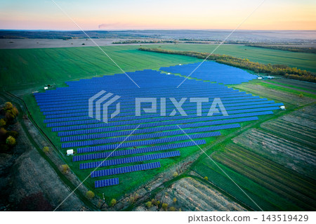 Aerial view of large solar power plant at sunset in agricultural fields, rows of photovoltaic panels Aerial view of large solar power plant at sunset in agricultural fields, rows of photovoltaic panels 143519429